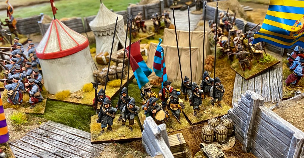 The gateway is barricaded and held by pikeman from the 'Foreign Infantry'.